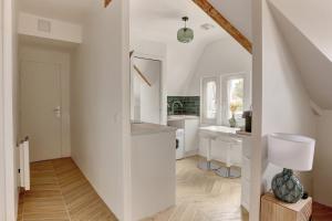 een witte keuken met een wastafel en een toilet bij Le Gresset - Vanves in Vanves +10 foto's