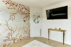 een woonkamer met een open haard en een tv aan de muur bij Le Gresset - Vanves in Vanves