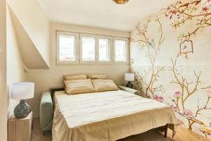 een slaapkamer met een bed en een bloemrijke muur bij Le Gresset - Vanves in Vanves