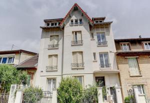 een groot wit gebouw met ramen bij Le Gresset - Vanves in Vanves