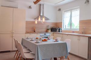 una cucina con tavolo e sedie e una cucina con tavolo e tavolo di Vila nostra familha a Vallon-Pont-dʼArc