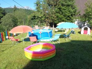 a backyard with a pool and chairs and umbrellas at Casa Roxana in Predeal