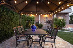 a table and chairs under an umbrella with a vase on it at Sunny Garden Lux in Split