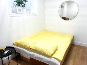 a yellow bed in a room with a mirror at Green Bridge Studio in Vilnius