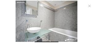 a bathroom with a sink and a bath tub at Cocon dans le centre in Bordeaux