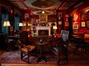 sala de estar con chimenea, mesa y sillas en The Zetter Townhouse Marylebone, en Londres