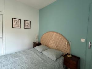 a bedroom with a bed and two pictures on the wall at Cocon dans le centre in Bordeaux