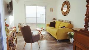 タルモンにあるDes vacances à 6 à Talmont St Hilaireの黄色いソファとテーブルのあるリビングルーム