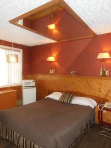 - une chambre avec un grand lit aux murs rouges dans l'établissement Motel Le Paysan, à Montréal