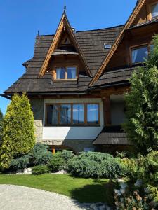 a house with a gambrel roof at Osada Białka Tatrzańska - apartamenty & domki z ogrodem dla rodzin, Odkryj-Bialke in Białka Tatrzańska