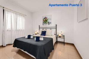 a bedroom with a large bed with blue pillows at Apartamentos Puerto 1, 2 y 3 in Playa Blanca