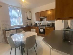 a kitchen with a table and chairs in a kitchen at 3-Bed House Near M1 & Meadowhall with Free Parking in Sheffield