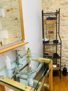 Chasseneuil-sur-BonnieureにあるMoulin du Fontcourtのバスルーム(ガラスの洗面台、鏡付)