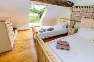 a bedroom with two beds and a window at Four bed barn conversion Junction 37 38 M1 in Barnsley