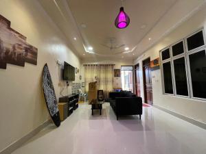 a living room with a black couch and a pink light at LETS GO HURAA in Huraa