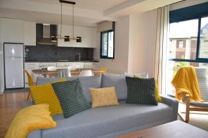 ein Wohnzimmer mit Couch und Küche in der Unterkunft Ventanal de Saras Petfriendly Garaje Trastero y Chimenea - Arafita Apartamentos in Panticosa