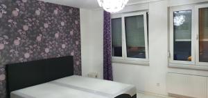 a bedroom with a bed with a floral wallpaper at Urlaubsfeeling wahrnehmen Perfekte Outdoor nur langzeit Vermietung! in Hamburg