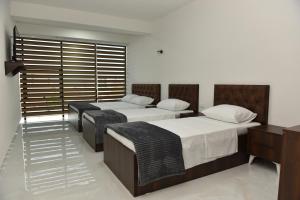 a room with three beds in a room at Hostel Jusaj Glob in Peje