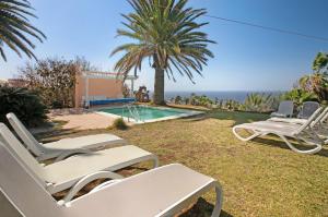 a group of lawn chairs sitting next to a swimming pool at Saint Maxime in Adeje