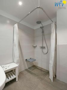 a bathroom with a shower with a shower curtain at Haus am Hövt - Ferienwohnung 10 in Göhren