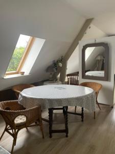 a dining room with a table and chairs and a mirror at Apple garden in Victot-Pontfol +1 photo