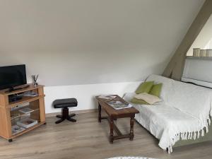 a living room with a couch and a table at Apple garden in Victot-Pontfol