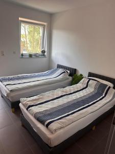 two beds sitting in a room with a window at AM Apartment in Gronau
