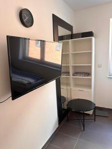 a room with a clock and a chair and a shelf at AM Apartment in Gronau