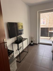 a living room with a flat screen tv on a wall at AM Apartment in Gronau +6 photos