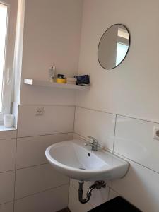 a white bathroom with a sink and a mirror at AM Apartment in Gronau +6 photos