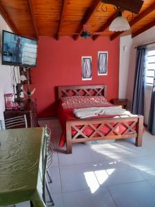a bedroom with a bed with a red wall at La lechon in Santa Teresita