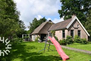 a slide in a yard in front of a house at OV598 6P holiday home with fenced garden by the water in Kalenberg in Kalenberg