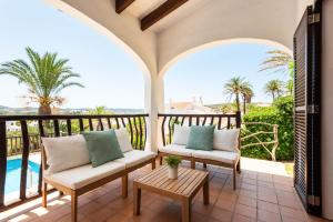 a patio with two chairs and a table on a balcony at Villas Playas de Fornells in Fornells