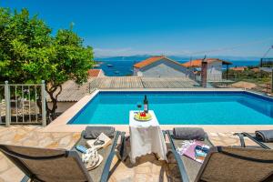 a swimming pool with a table and chairs next to a pool at Villa Thea Antonis in Gaios
