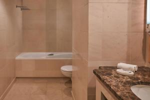 a bathroom with a tub and a toilet and a sink at Hyatt Regency Nice Palais de la Méditerranée in Nice