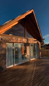 a house with glass doors on a wooden deck at Mirador in San Pedro