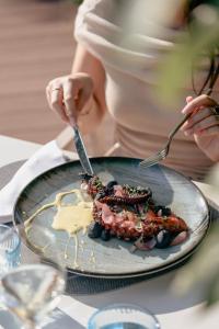 a woman holding a plate of food on a table at Astoria Resort in Riva del Garda