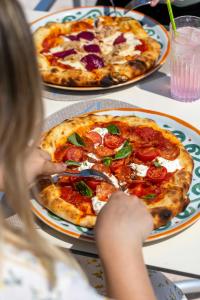 a young girl is eating a pizza on a table at Astoria Resort in Riva del Garda