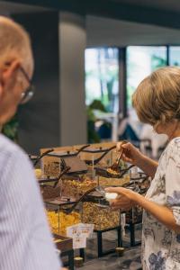a woman standing in front of a display of food at Astoria Resort in Riva del Garda