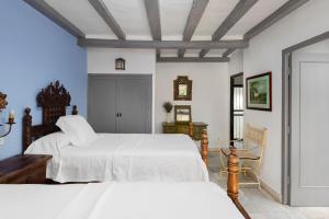 ein Schlafzimmer mit zwei Betten mit weißer Bettwäsche in der Unterkunft Suites Cortijo Fontanilla in Conil de la Frontera + 68 Fotos