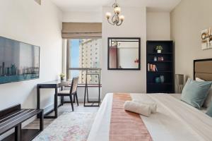 a bedroom with a bed and a desk and a table at La Buena Vida Holiday Homes - Modern, Luxe & Spacious 4-Bed, Full Kitchen, near to Beach, Tram & Marina in Dubai