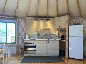 una cocina con estufa y refrigerador en היורט על הגג - צוקים, en Tzukim 14 fotos más