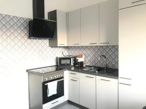 a kitchen with white cabinets and a microwave at Hollabrunn-Rest-Relaxation-Garden contactless check-in in Hollabrunn