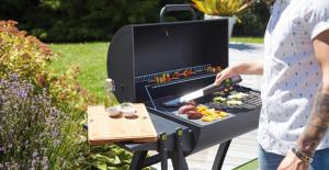 a man is cooking food on a barbecue grill at Hollabrunn-Rest-Relaxation-Garden contactless check-in in Hollabrunn