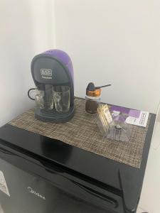 a coffee maker sitting on top of a microwave at Refúgio das Ondas I Suítes perto da praia com conforto e self check-in in Bertioga