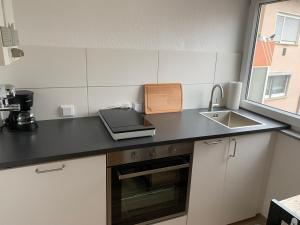 a kitchen with a counter top with a sink at HMS16 I 1-Zimmer Apartment mit Balkon I Daimler Nähe I S-Bahn & City - Sindelfingen in Sindelfingen
