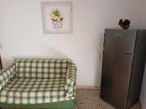 a chair sitting next to a refrigerator in a room at Le Casette di Nonna Rosa in Fontanarossa Catania Airport in Catania