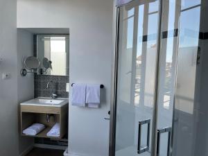 a bathroom with a sink and a glass shower at Hôtel de France - Beaune in Beaune +26 photos