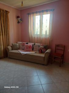 Una sala de estar con un sofá y una ventana. en Sourlis house, en Esparta