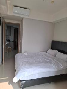 Schlafzimmer mit einem großen weißen Bett in der Unterkunft Seaview gold coast pik bisnis room in Jakarta